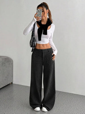 Chic wide-leg corduroy trousers in black with front pockets, styled casually.