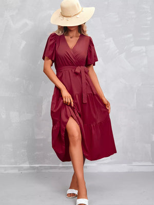 Scarlet flutter sleeve tiered midi dress with wrap neckline and belted waist.