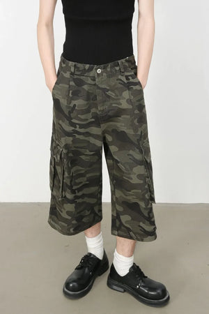 Pleated camo culotte cargo shorts in green camouflage with buttoned front and side cargo pockets.