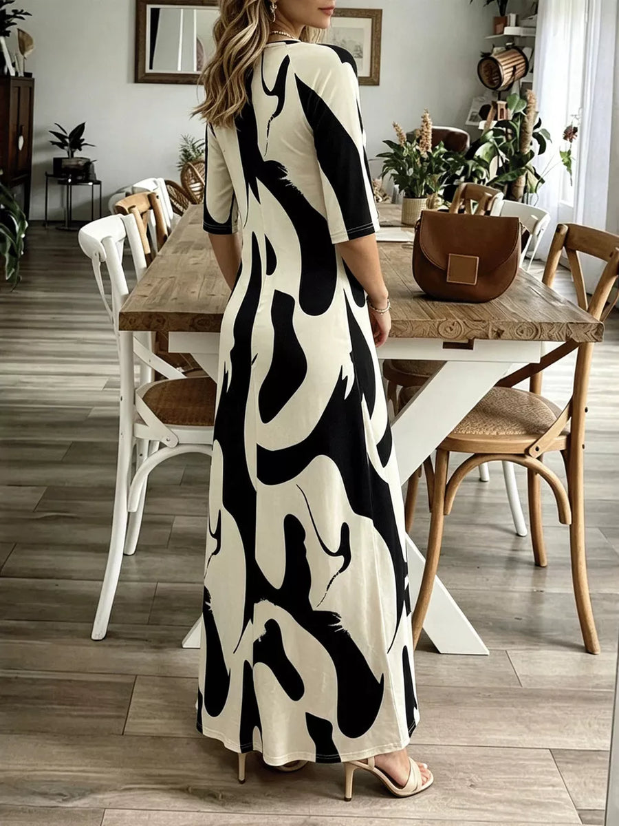 Maxi dress with abstract print, V-neck, 3/4 sleeves, and flowing skirt.
