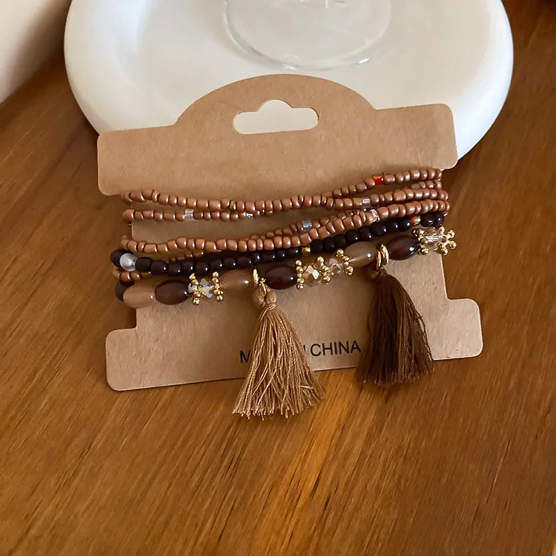 Beaded tassel stacked bracelet set in coffee brown and bronze with gold accents.