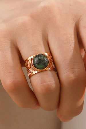 Leaf-cut gold ring with oval malachite stone and openwork leaf design.