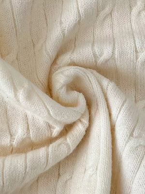 Chic cable-knit cropped cardigan in apricot acrylic fabric with textured detail.