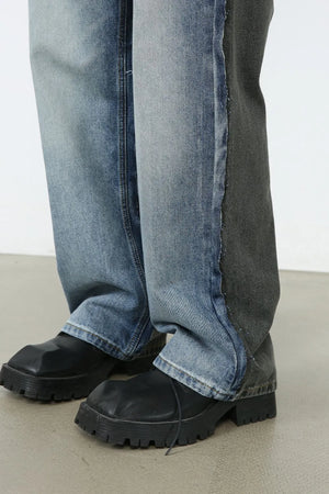 Paneled wide-leg denim trousers in medium wash and charcoal with a contrast seam detail.