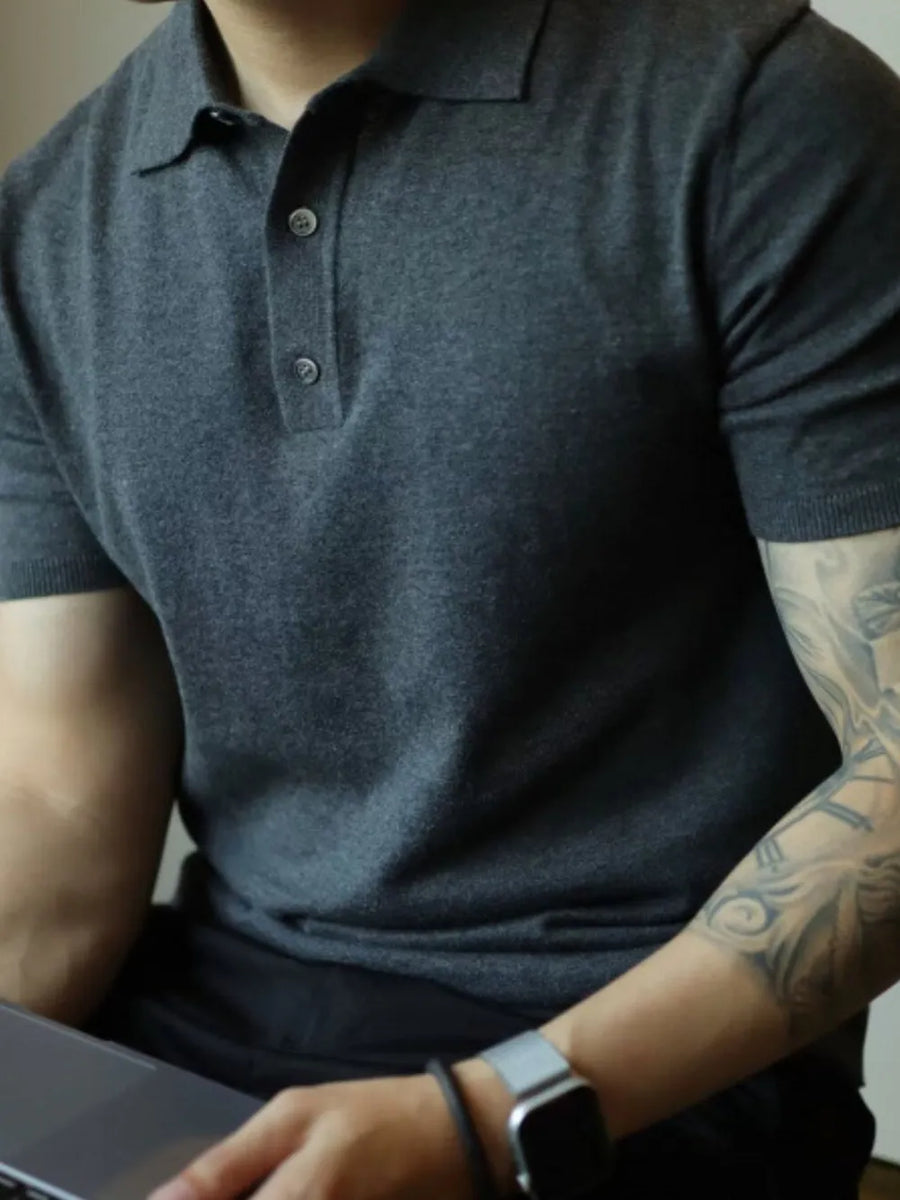 Dark gray fine-gauge knit polo shirt with a refined button placket and short sleeves.
