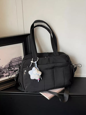 Black quilted nylon tote bag with star charm and multiple zippered pockets