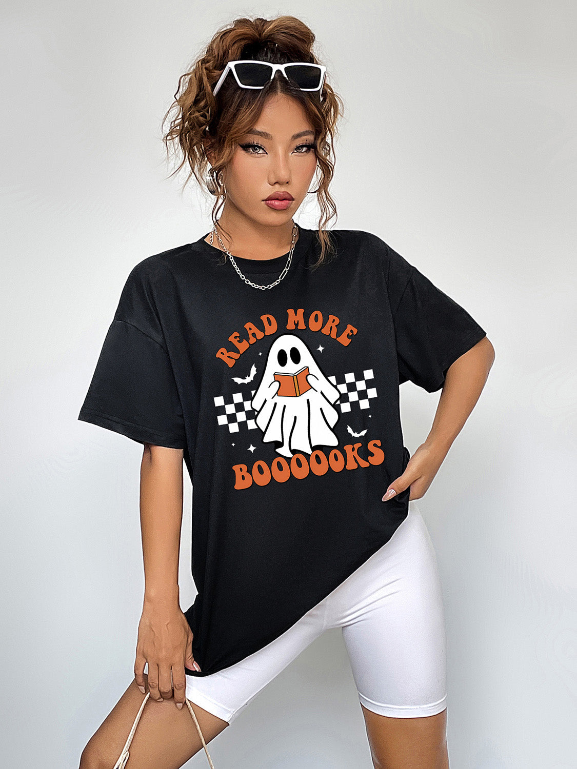 Black graphic t-shirt with a ghost reading a book and Halloween text.