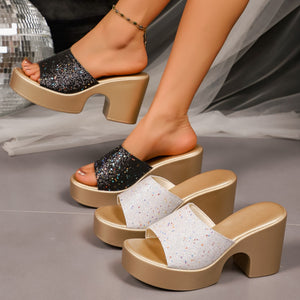 Glittering open-toe block heel sandals in black and white with gold platforms.