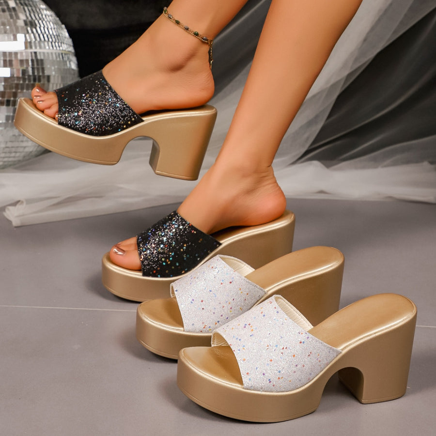 Glittering open-toe block heel sandals in black and white with gold platforms.