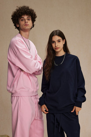 Pink crewneck sweatshirt with matching drawstring pants and navy crewneck sweatshirt with matching drawstring pants