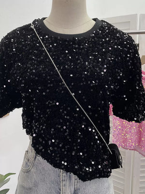 Black sequin t-shirt with crew neck and short sleeves, styled with a crossbody bag.