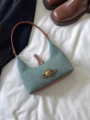 Mini canvas shoulder bag in light blue denim with brown trim and planet star emblem.