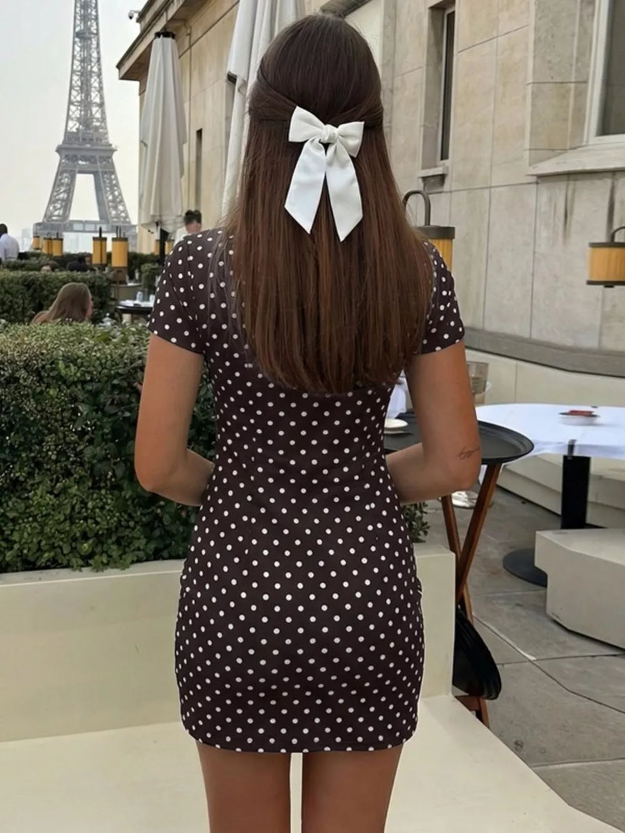 Brown polka dot mini dress with short sleeves and a cut-out detail.