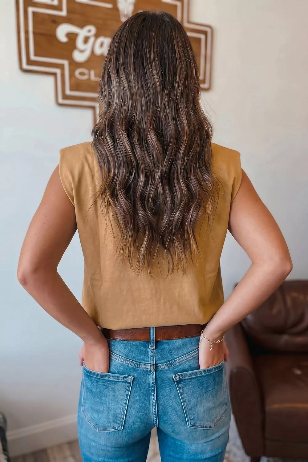 Taupe sleeveless tank top with shoulder pads, styled with jeans.