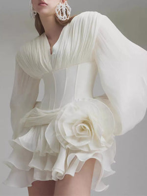 White ruffle mini dress with balloon sleeves, V-neck, corset waist, and large floral applique.