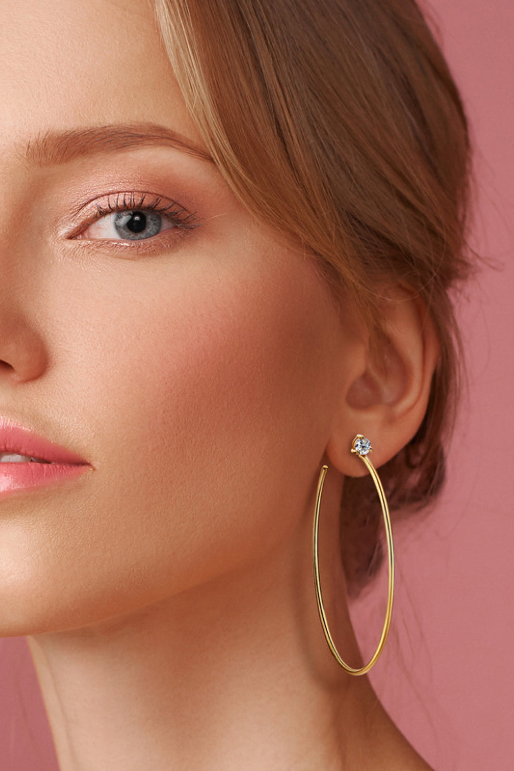 Gold hoop earrings with a single clear stone