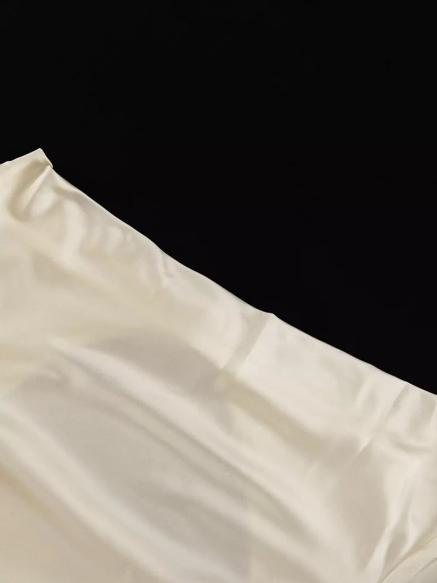 Cream silk fabric with a subtle sheen and draped folds.
