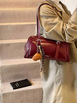 Deep Red vintage leather shoulder bag with buckle details and charm.