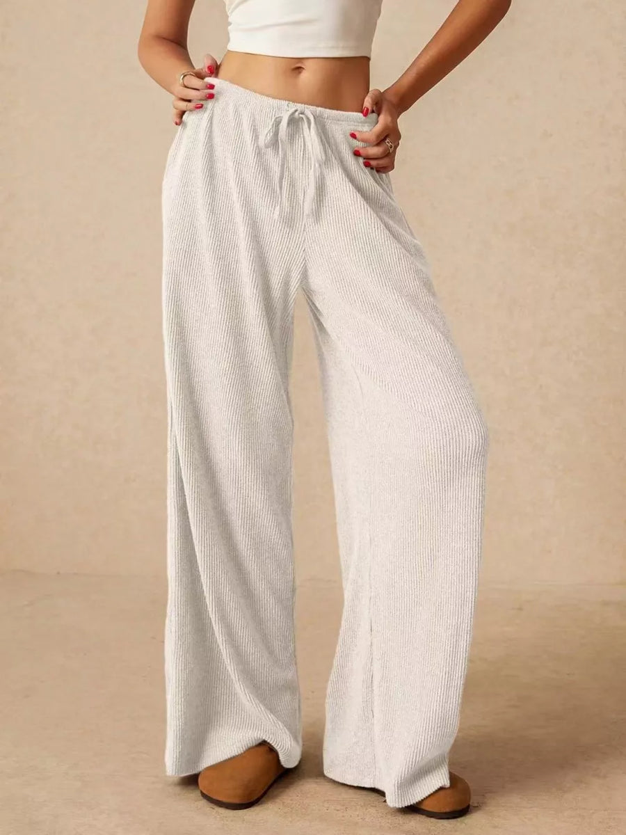 White ribbed wide-leg drawstring pants with a relaxed fit.