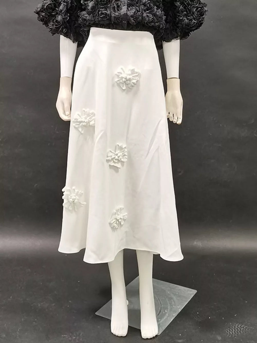 White midi skirt with floral applique detail.