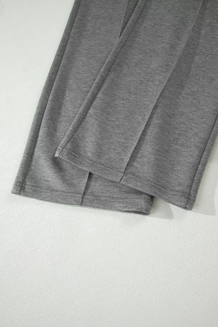Dark gray wide-leg pants with stitched front detail and cuffed hems.