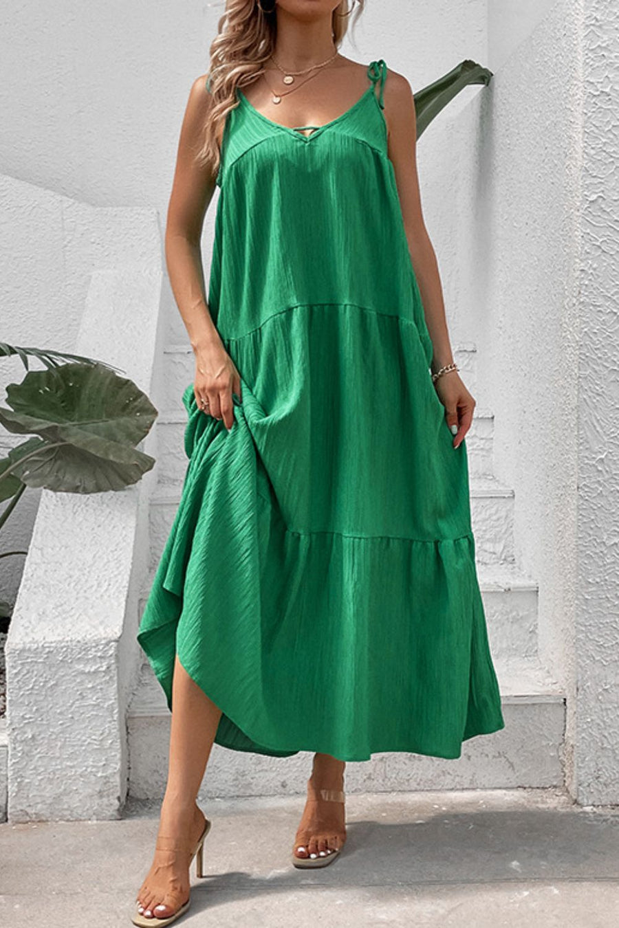 Green tiered maxi dress with delicate tie straps and textured fabric.