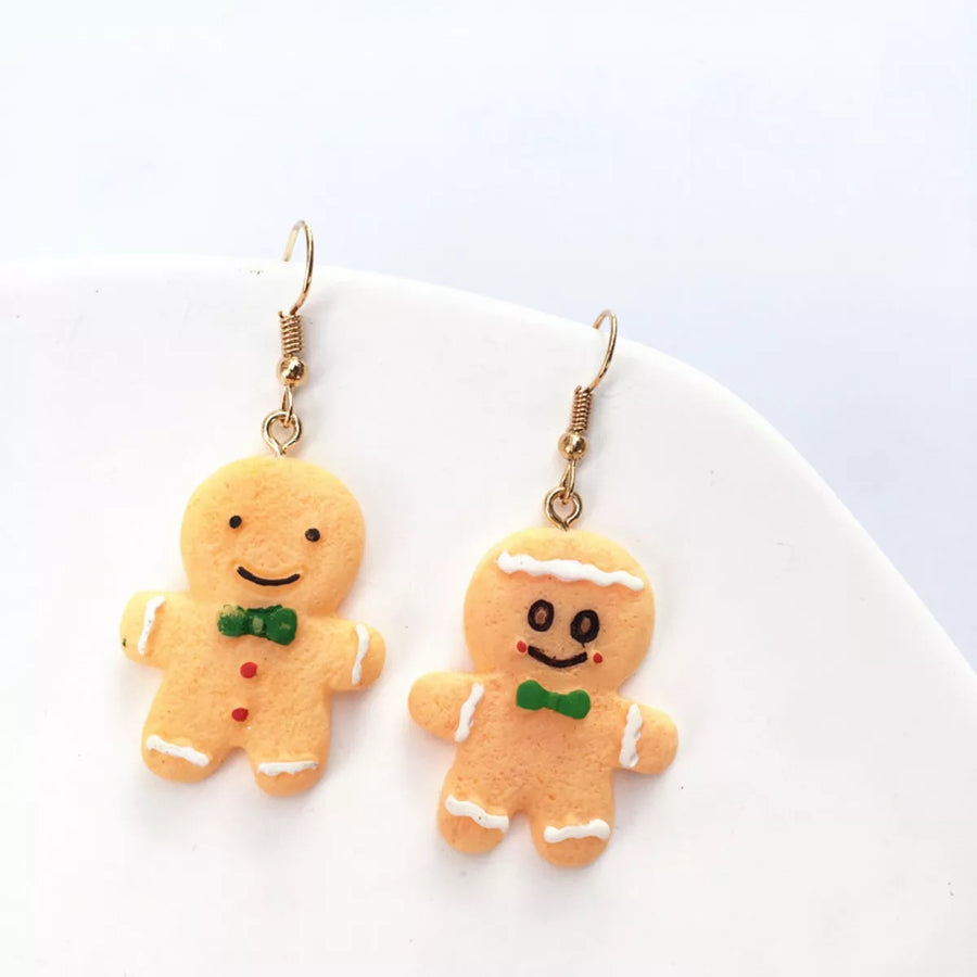 Gingerbread man holiday earrings with green bow ties and white icing details.