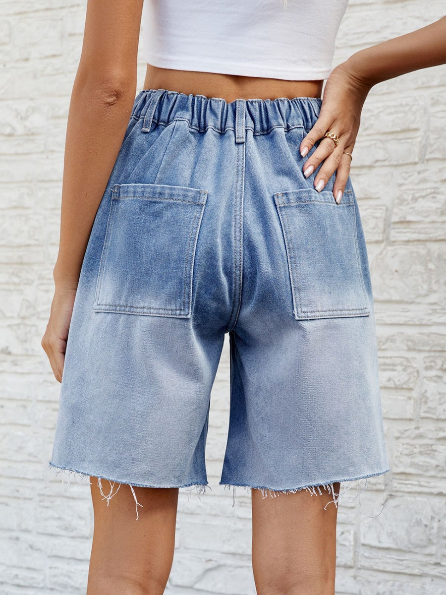 Light blue faded denim carpenter shorts with raw hem and elastic waistband.
