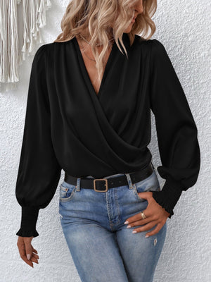 Black ruched surplice blouse with long balloon sleeves and smocked cuffs.