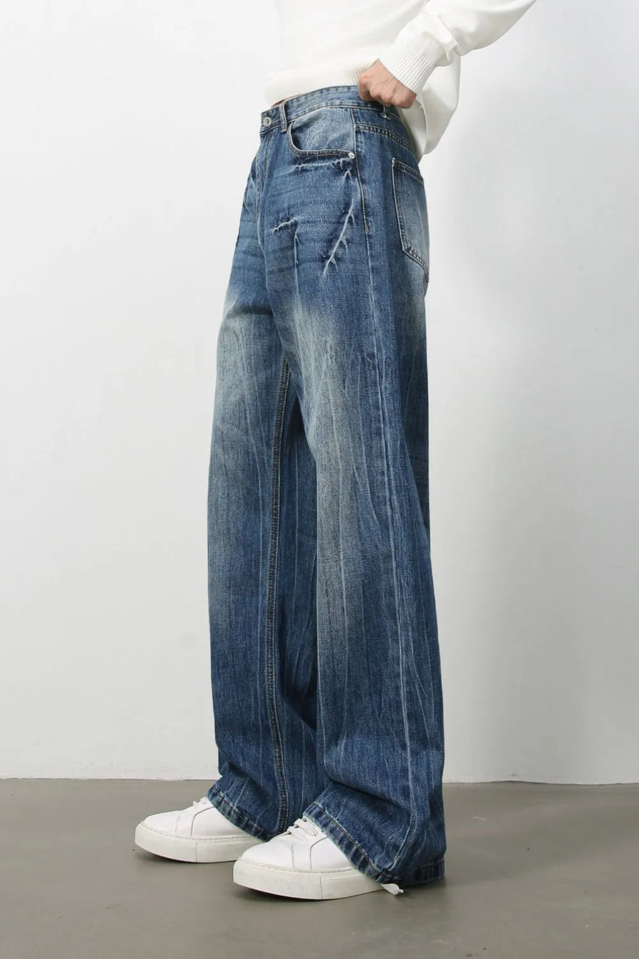 Wide-leg distressed denim jeans in vintage wash with a relaxed fit and frayed details.