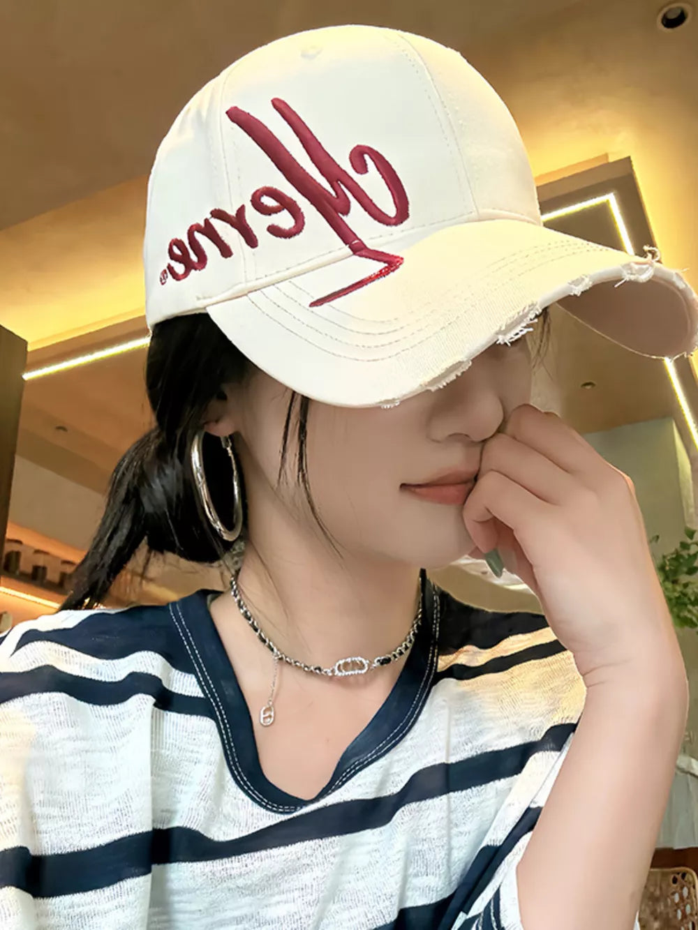 Off-white distressed baseball cap with red embroidery and frayed brim
