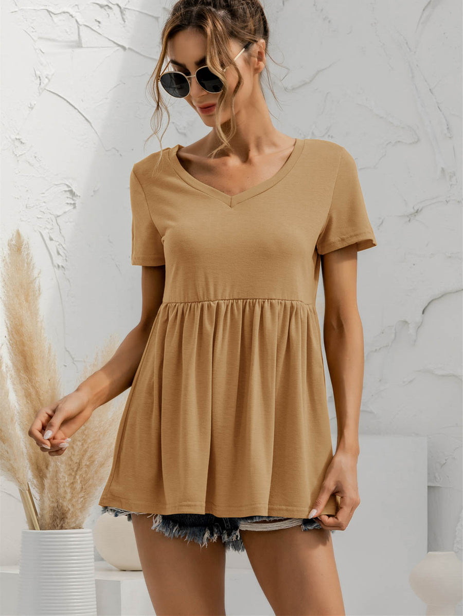 Khaki v-neck tee with gathered waistline and short sleeves, styled with denim shorts.