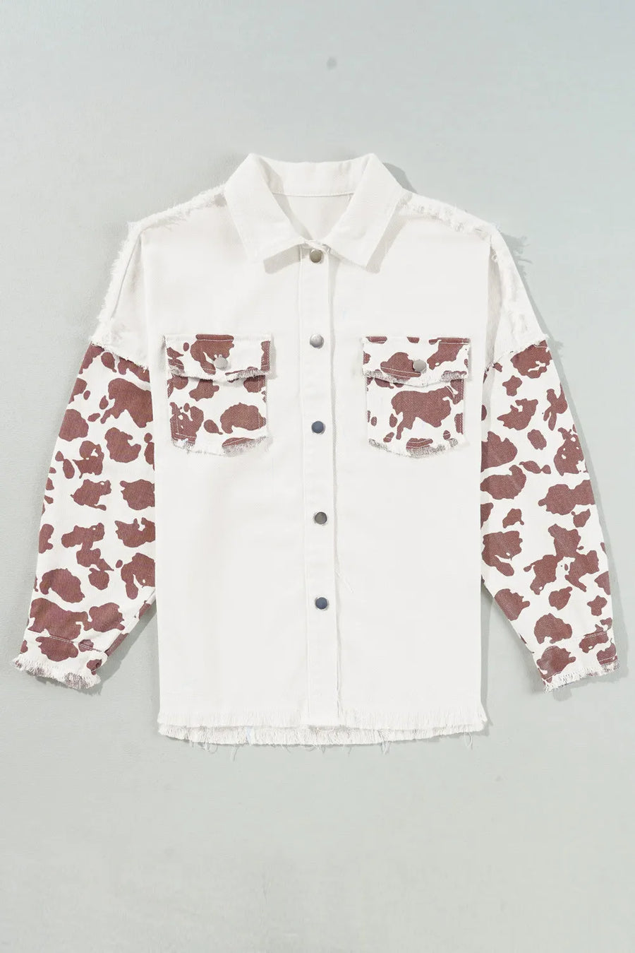 White cotton shacket with cow print sleeves and frayed edges.