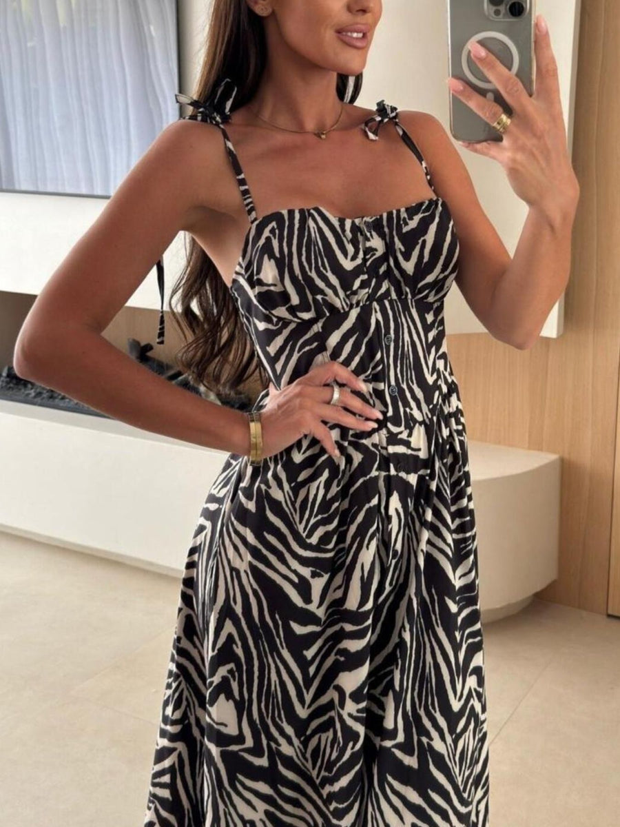 Tie-shoulder midi dress with zebra print, adjustable straps, and button front.