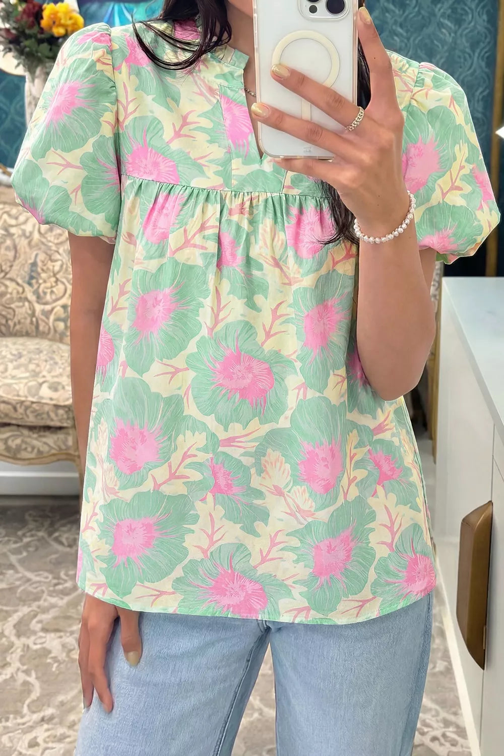 Pastel floral puff sleeve blouse with ruffled neckline and smocked bodice.