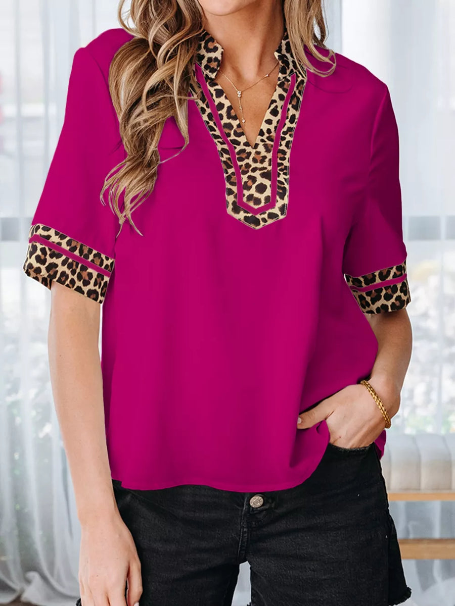 Fuchsia split neck blouse with leopard trim on neckline and sleeves.