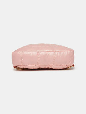 Glossy padded sling bag in pink with quilted detail and gold hardware.