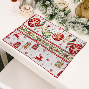 Embroidered Christmas placemat with ornaments, reindeer, and gifts in red and green.