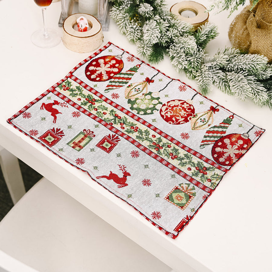 Embroidered Christmas placemat with ornaments, reindeer, and gifts in red and green.