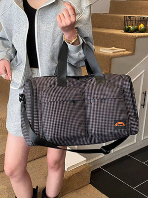 Chic medium plaid duffel bag with front pockets and adjustable strap.