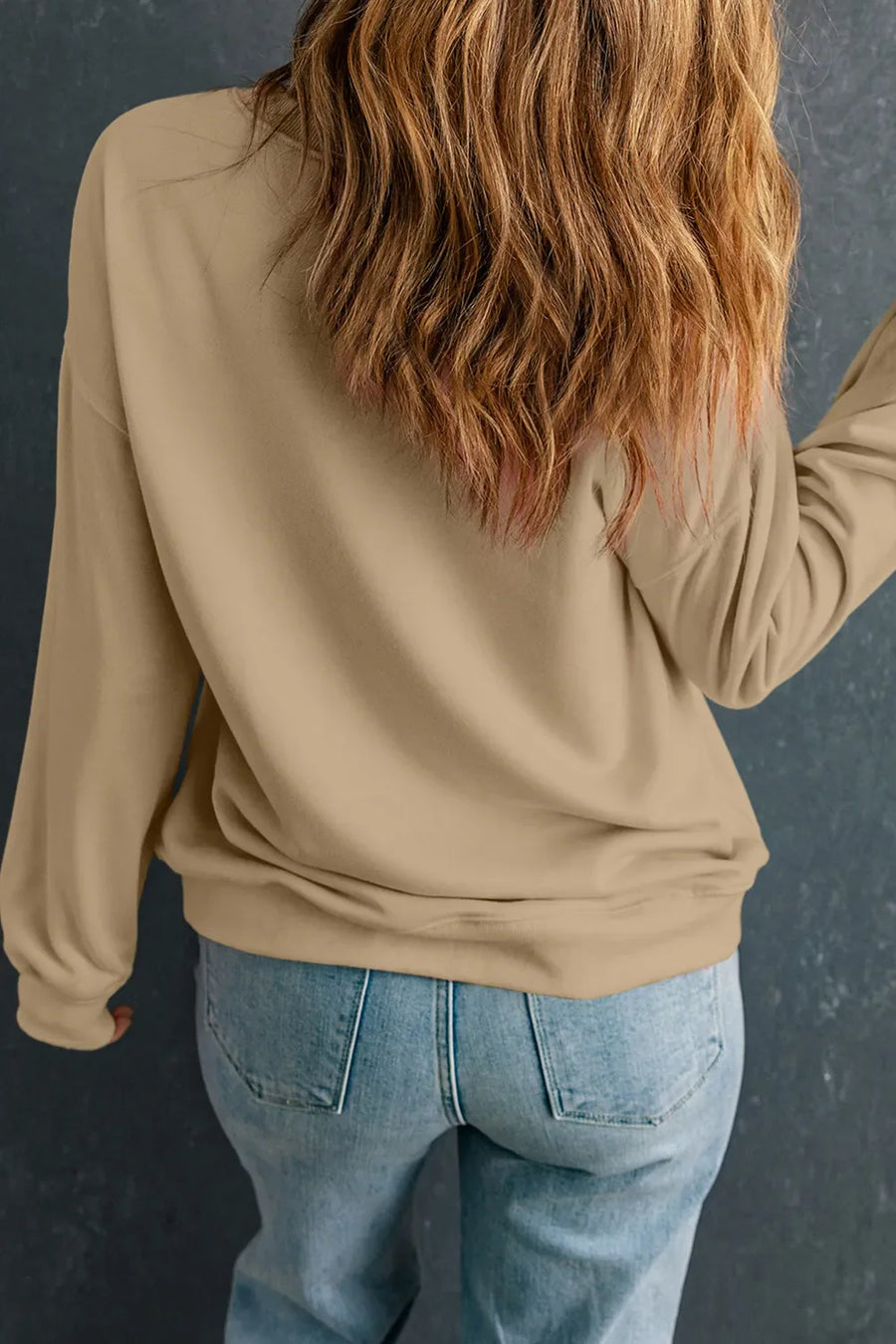 Khaki drop shoulder sweatshirt with long sleeves, casual fit, paired with light wash jeans.