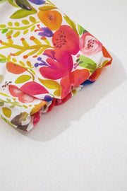 Vibrant floral cotton mini dress with bold watercolor blooms and tiered detail.