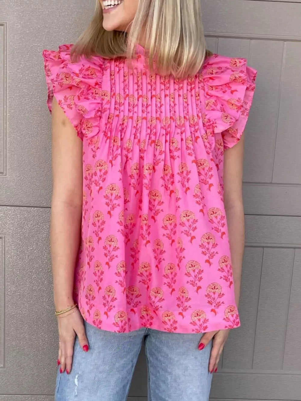 Pink floral print blouse with ruffled flutter sleeves and pintuck detail.