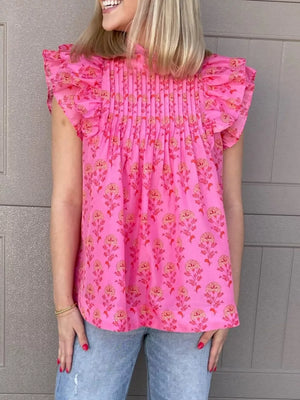 Pink floral print blouse with ruffled flutter sleeves and pintuck detail.