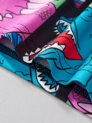 T-shirt with cartoon shark print in blue, pink, and black.