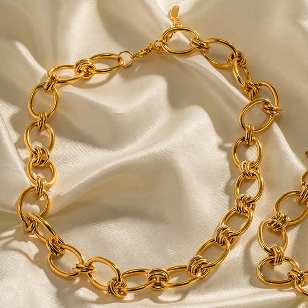Chunky gold link collar necklace with toggle clasp on satin fabric