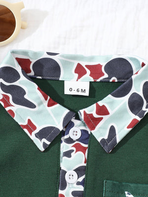 Dark green baby polo with camouflage collar and placket, two white buttons.