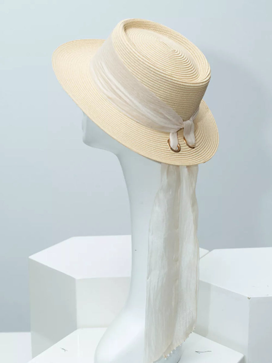 Elegant straw sun hat in ivory with sheer ribbon and pearl embellishments.