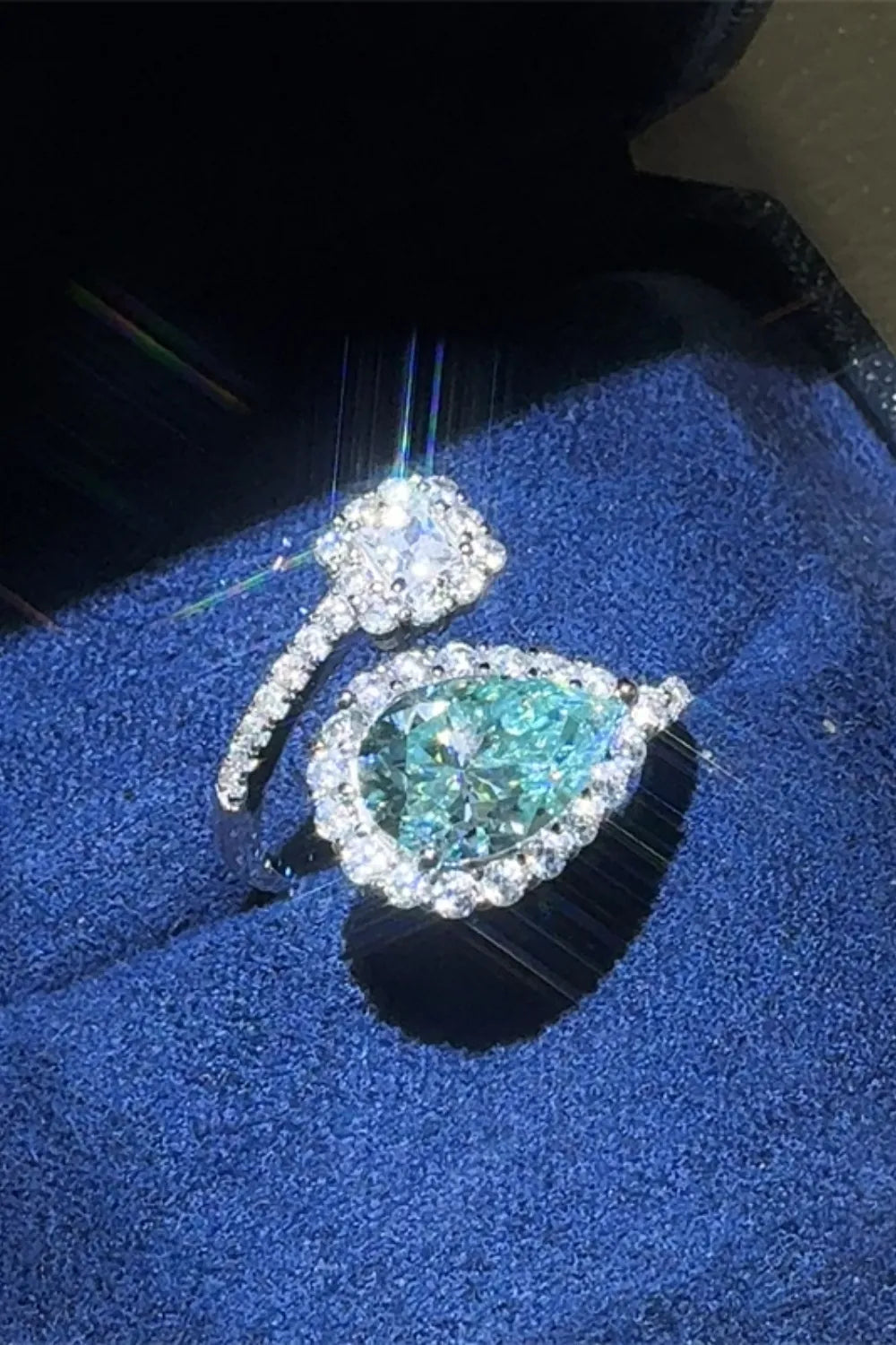Turquoise bypass pear-cut moissanite halo ring with pave band.