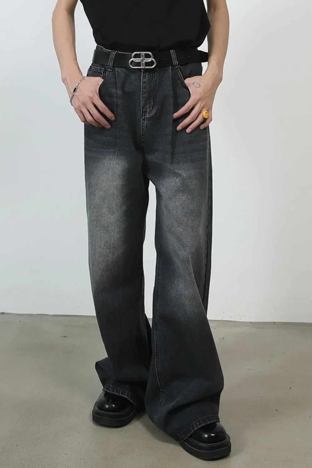 Black faded wash pleated palazzo jeans with a wide leg and a relaxed fit.
